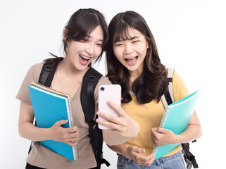 Excited Asian female students watching the smart phone