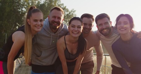 Happy sporty frineds together smiling, diverse group of young adults posing for picture outdoors, joyful fun after athletic activity, shared achievement and friendship joy team gathering to motivate 