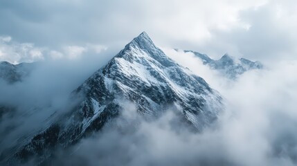 Snowy mountain peak rises above the clouds in a majestic winter landscape
