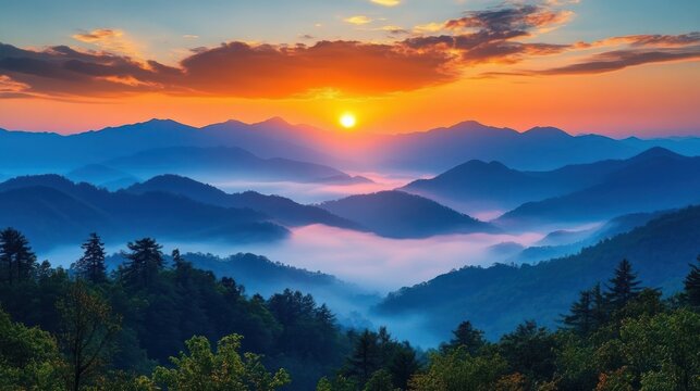 Sunrise over a mountain range with layers of hills covered in mist and trees under a colorful sky with clouds