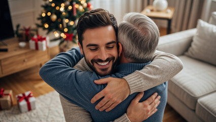 Happy young man embracing his elderly father in a cozy living room with a Christmas tree. Family holiday celebration and reunion