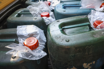 Close up of green plastic jerrycan and canister for fuel or liquid transportation. group of...