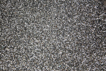 Close-up of textured pedestrian walkway surface made of small gravel.