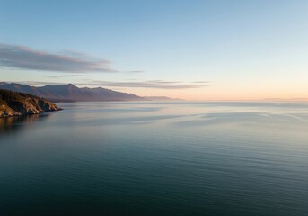 Fototapeta premium Serene coastal strait unfolds under the gentle light of a crisp sunrise and pastel sky.