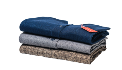 A stack of three folded sweaters, one blue, one gray, and one patterned brown, with a tag, png cutout