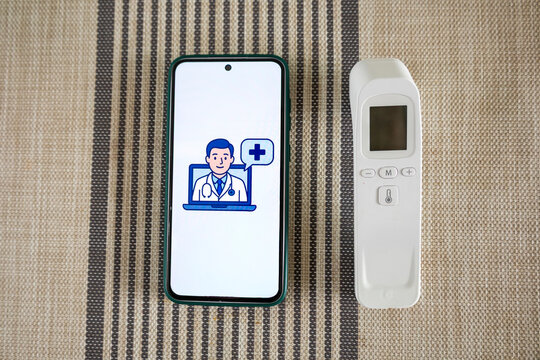 Smartphone displaying online doctor and non contact thermometer representing telemedicine