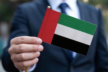 Elegant businessman showcases the vibrant UAE flag in a show of patriotism and national pride, celebrating United Arab Emirates