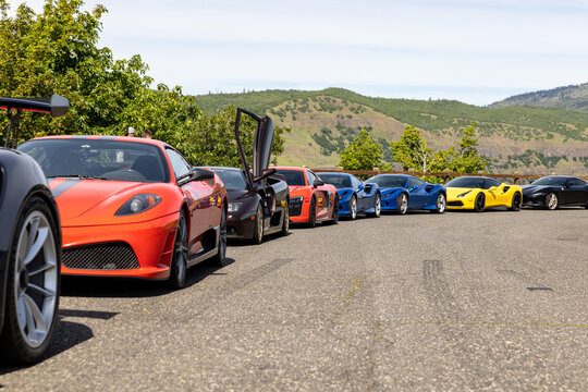 Mosier, Oregon \ USA - 22 May 2022: Colorful lineup of exotic supercars at Rowena Plateau Overlook with mountain backdrop