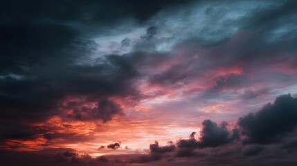 Obraz premium A dramatic twilight sky filled with fiery orange and pink clouds creating a moody and serene atmosphere