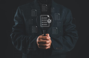 Document review process and quality control concept. Businessman holding magnifying glass over a document icon with checklist, document review and approval. Certificate management, Audit, certified