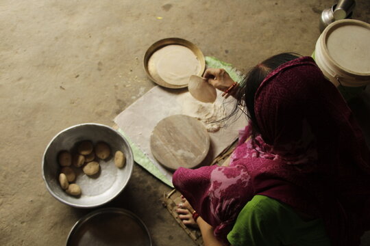 Indian Woman Rolling Roti or Chapati Dough with Wooden Rolling Pin on Chakla, Traditional Indian Cooking, Homemade Flatbread Preparation and Food Culture