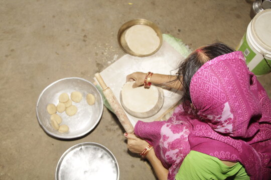 Indian Woman Rolling Roti or Chapati Dough with Wooden Rolling Pin on Chakla, Traditional Indian Cooking, Homemade Flatbread Preparation and Food Culture