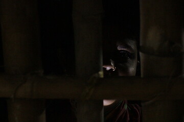 Artistic woman&rsquo;s face lit in darkness, expressing resilience, life, and emotion through shadow and subtle human expression.