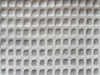 Close up of white fabric in square checkerboard or checkered pattern. 3D checkerboard white tufted fabric suitable for upholstery, carpet, or soft seating. Seamless background texture.