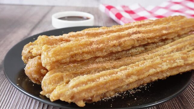 Zoom out on a plate of churros with sugar and cinnamon. Mexican food