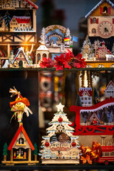 Handcrafted wooden Christmas decorations including miniature houses, sleigh, trees, and ornaments arranged in a colorful holiday display.