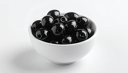 A bowl of glossy black olives sits on a clean white surface with soft shadows and a crisp white background creating a simple and elegant presentation ideal for culinary and food photography.