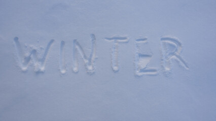 Winter text on snowy background. Snowy banner design in cold weather. Winter text with snowflakes. Snow background with winter text.