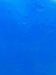 smooth electric blue plaster cement wall taken from a vertical front angle