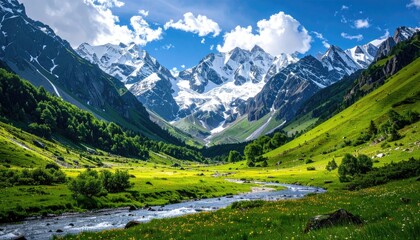 Vast Green Valley With Snow Capped Mountains And Winding River Under A Blue Sky With White Clouds