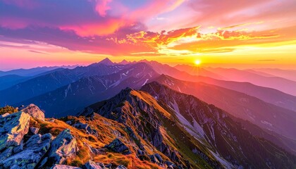 Sunset ignites rugged mountain peaks in vivid hues, casting dramatic shadows across a breathtaking landscape.