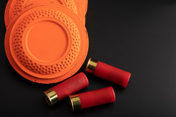 Clay shooting target and shotgun bullets on black background ,Clay Pigeon target game