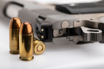 .45 or 11 mm. ammunitions and automatic hand gun on white background