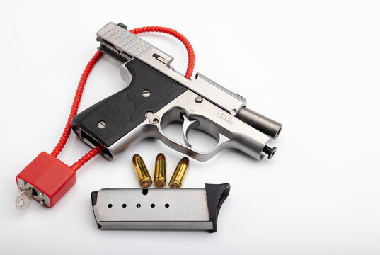 9 mm.Bullets  with Locked disarmed and secured automatic hand gun on white background , Gun safety concept