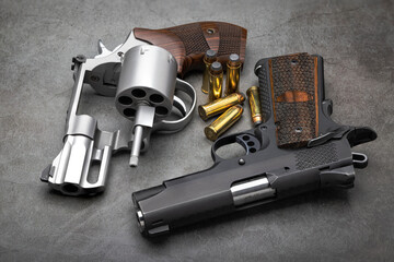 Revolver and semi automatic pistol hand gun with bullets on texture background