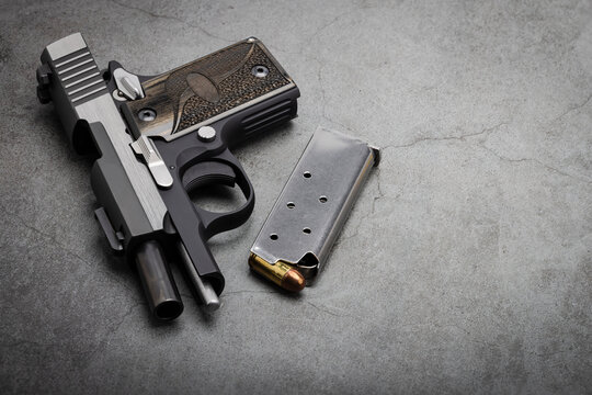 Semi automatic pistol hand gun with bullet magazine on texture background , Back up gun