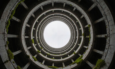 Fototapeta premium Vacant cooling tower Interior of a cooling tower, towering round walls converging to an open sky circle, wide fisheye lens