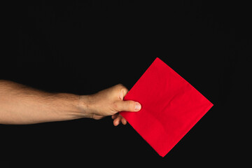 Obraz premium Holding a red square cloth against a dark background