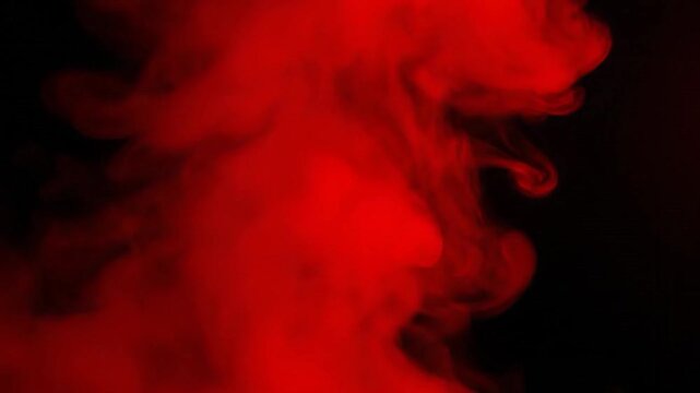 Abstract image of swirling, bright red cloud against dark background with ethereal shapes