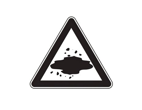 Black and white triangular road sign showing a hazard of potential debris or spillage ahead
