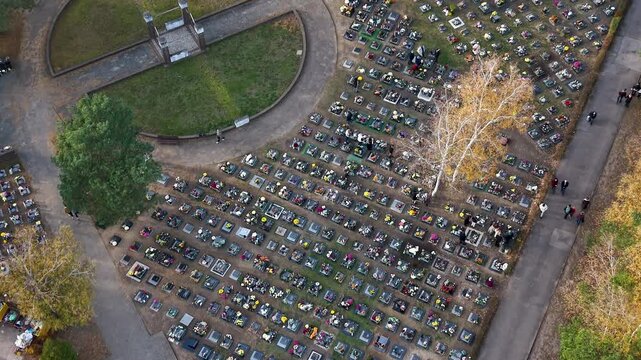 Aerial cemetery graves autumn Bydgoszcz city Poland 4K. All Saints' Day, annual night cemetery family gathering. Graves covered with flowers and lights for the dead. Funeral final destination. Modern.