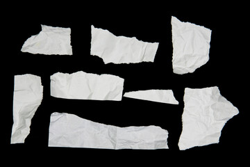 White paper cut with torn edges isolated on black background.