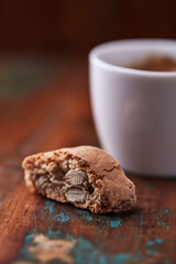 Cantuccini (Italian cookie) and a cup of coffee on dark wooden background. Close up.	