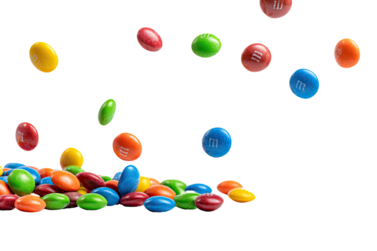 Candy-coated chocolate lentil pile, falling. Isolated black