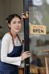 Small business owners who are successful in business asian woman standing with a sign Opening a coffee shop, independent business, female barista, startup idea, SME business.
