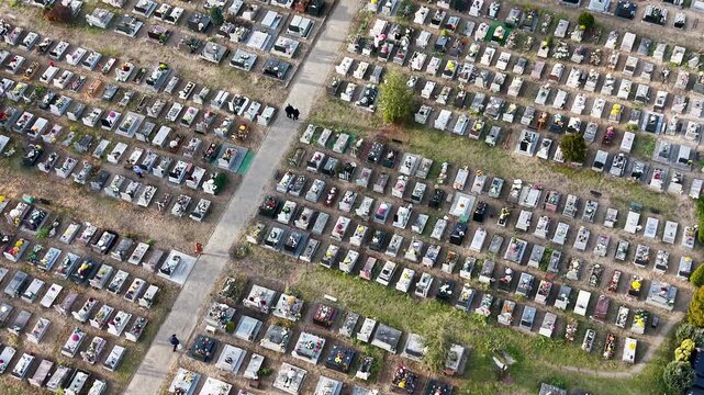 Aerial cemetery graves autumn Bydgoszcz city Poland 4K. All Saints' Day, annual night cemetery family gathering. Graves covered with flowers and lights for the dead. Funeral final destination. Modern.