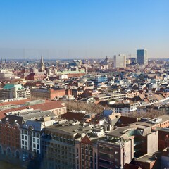 Fototapeta premium Antwerp, Belgium, cityscape with diverse urban architecture, many rooftops, and a prominent church spire on a sunny day