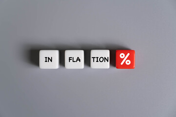 Inflation Concept with Dice and Percentage Symbol. four cubes arranged in a row on a smooth gray background. Symbolizing rising interest rates, economic pressure, or increasing prices.