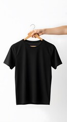 Hand holding a blank black t-shirt on a wooden hanger against a white background. Front view apparel mockup for custom design and branding