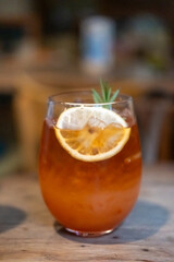 Tropical drink juice, with lemon on top, on the wooden table