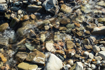 Rapid water stream river close up stones with sunlight  and motion blur