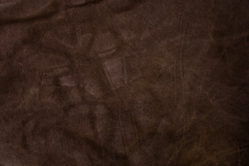 Genuine leather suede skin, textured surface, dark brown close up parchment structure , abstract backdrop