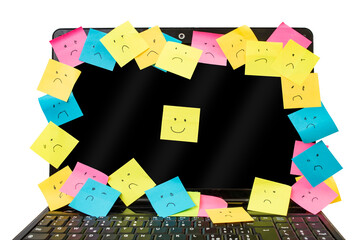 Many colorful sticker posts with sad and smile expressions on a black laptop screen isolated on white background, workplace happiness metaphor