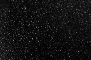 Water drops condensation mist on glass surface on black background, close up