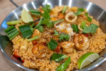 Seafood Tom yum fried rice, a dish of rice  with tom yum paste, garlic and chili fried with prawn, squid and mussel, served on a pan