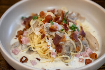 Spaghetti Carbonara with ham and bacon served on a white plate. Soft Focus.
